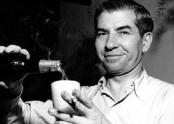 A picture of a smiling Lucky Luciano pouring a glass of wine.