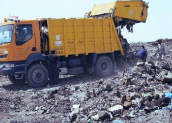 A garbage truck dumping garbage.