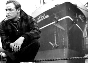 A photo of a young Marlon Brando sitting on a dock from the film On the Waterfront.
