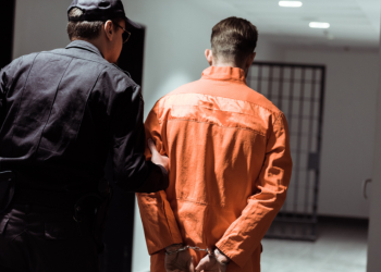 A prisoner is being escorted to his jail cell.