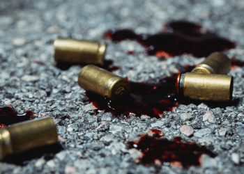 A photo of bullets hitting the ground in a pool of blood.