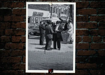 A photo of several men with fedoras talking on a street in Queens, NY
